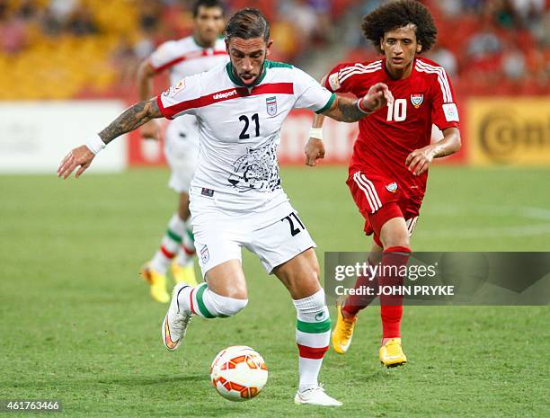 Ashkan Dejagah of Iran dribbles the ball ahead of Omar Abdulrahman of the United Arab Emirates during their Group C football match at the AFC Asian...