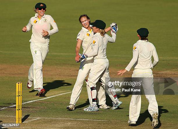 Ellyse Perry and Jodie Fields of Australia celebrate the wicket of Lydia Greenway of England during day two of the Women's Ashes Test match between...