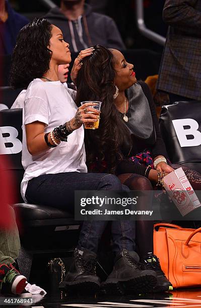 Rihanna and guest attend the Miami Heat vs Brooklyn Nets game at Barclays Center on January 10, 2014 in the Brooklyn borough of New York City.