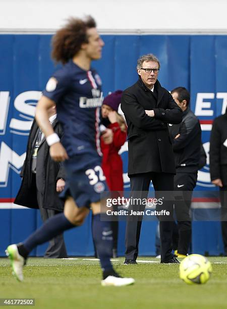 Head coach of PSG Laurent Blanc looks on while David Luiz of PSG hits the ball during the French Ligue 1 match between Paris Saint-Germain FC and...