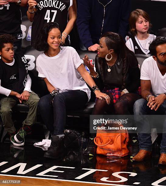 Rihanna and guest attend the Miami Heat vs Brooklyn Nets game at Barclays Center on January 10, 2014 in the Brooklyn borough of New York City.