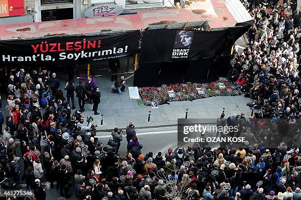 Turkish people gather in front of the office of Armenian newspaper "Agos" as a placard reading '' Face Hrant -Face with Genocide'' during a...