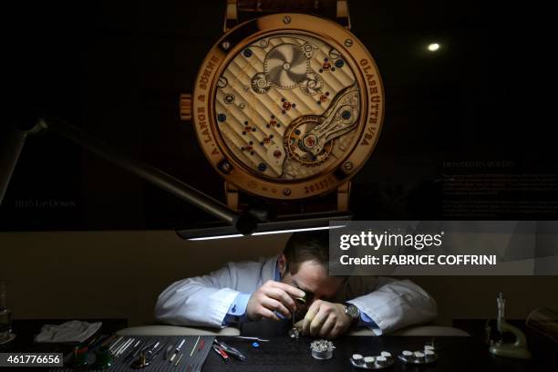 An employee of German watchmaker A. Lange & Soehne assembles a wristwatch on January 19, 2015 during the opening day of the "Salon International de...