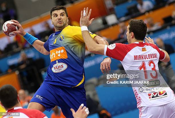 Bosnia and Herzegovina's Nikola Prce attempts a shot on goal despite of Macedonia's Filip Mirkulovski during their 24th Men's Handball World...