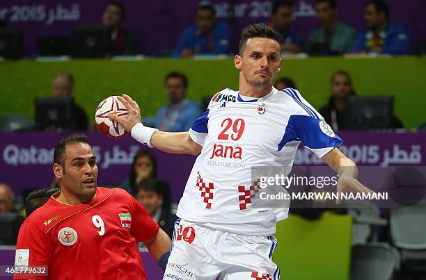 Iran's Mahdi Bijari looks on as Croatia's Ivan Nincevic attempts a shot on goal during the 24th Men's Handball World Championships preliminary round...