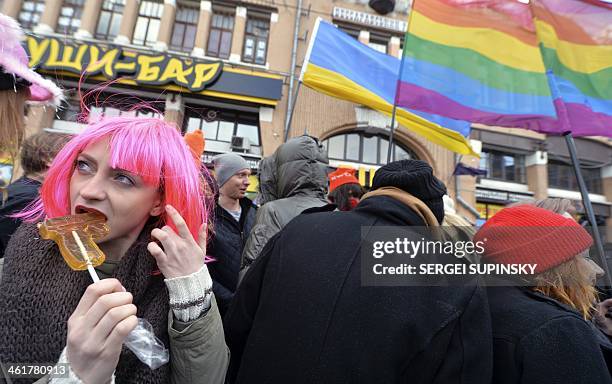 Woman eats a gun-shaped candy as people take part in a pro-European Union activistsunder the slogan "EuroMaidan is a chance for everyone to be heard...