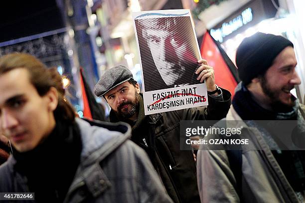 Man holds a poster depicting slain journalist Hrant Dink and reading "Despite fascism Hrant is our brother" during a march in memory of Dink, on...