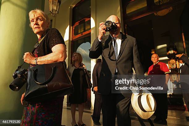 Sen. Patrick Leahy takes photographs of journalists assembled outside the Hotel Saratoga after departing the hotel with his wife Marcelle Pomerleau...