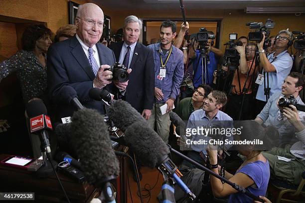 Sen. Patrick Leahy takes photographs of the journalists assembled for a news conference with Sen. Sheldon Whitehouse at the Hotel Saratoga January...