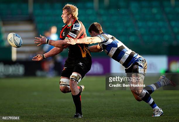 Jevon Groves of Newport passes under the tackle of Ollie Devoto of Bath during the Amlin Challenge Cup match between Newport Gwent Dragons and Bath...