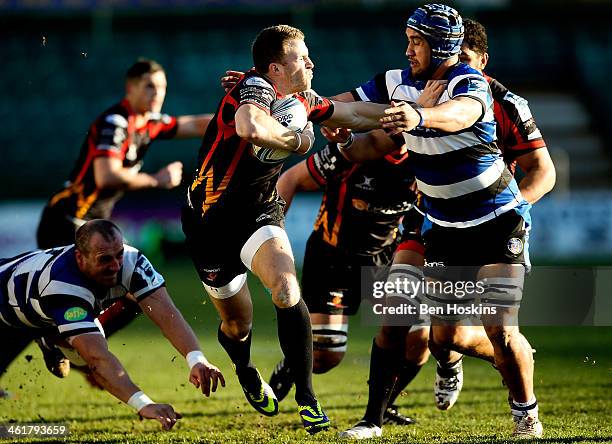 Ashley Smith of Newport hands off the tackle of Leroy Houston of Bath during the Amlin Challenge Cup match between Newport Gwent Dragons and Bath at...