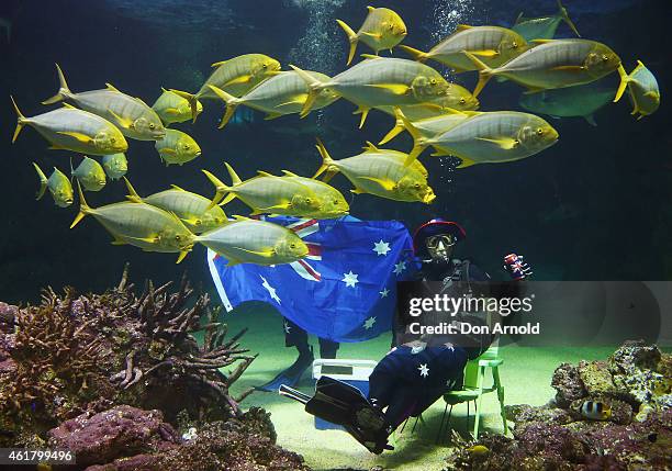 Divers pose with an Australian flag and an esky during Australia Day underwater party at SEA LIFE Sydney Aquarium on January 20, 2015 in Sydney,...