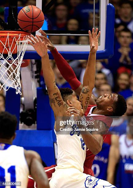 Kelly Oubre Jr. #12 of the Kansas Jayhawks fouls Buddy Hield of the Oklahoma Sooners during the game at Allen Fieldhouse on January 19, 2015 in...