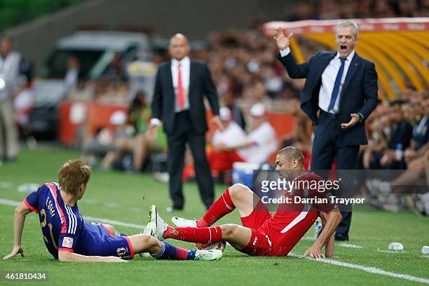 Gotoku Sakai of Japan is taken down by Odai Al Saify of Jordan as coach of Japan Javier Aguirre reacts during the 2015 Asian Cup match between Japan...