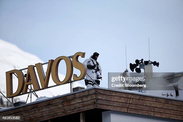 Armed members of the Swiss police force monitor the town during security operations from the roof of the Hotel Davos ahead of the World Economic...