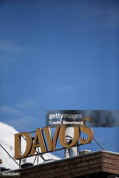 Member of the Swiss Police force uses binoculars to look out across the town from the rooftop of Hotel Davos during security operations ahead of the...