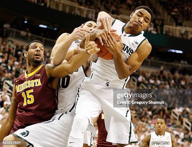 Gary Harris of the Michigan State Spartans grabs a first half rebound next to Maurice Walker of the Minnesota Golden Gophers at the Jack T. Breslin...