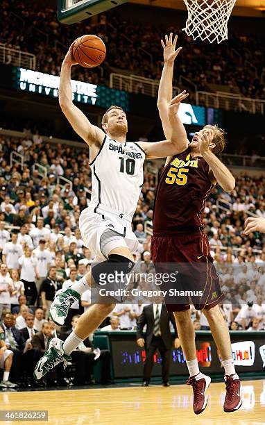 Matt Costello of the Michigan State Spartans flies to the basket past Elliott Eliason of the Minnesota Golden Gophers during the second half at the...