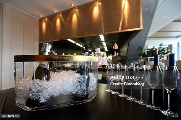 Champagne glasses stand near an ice bucket containing bottles of Louis Roederer champagne on the bar at the InterContinental Hotel Davos, operated by...