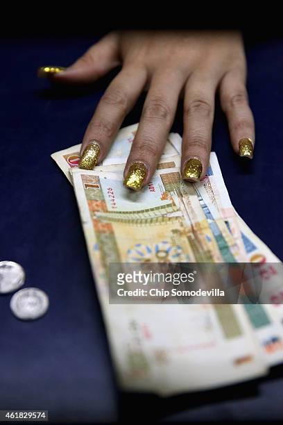 With gold painted fingernails, a currency exchange official trades CUCs for U.S. Dollars at Jose Marti International Airport January 19, 2015 in...