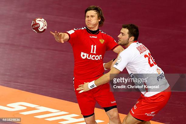 Mariusz Jurkiewicz of Poland defends against Pavel Atman of Russia during the IHF Men's Handball World Championship group D match between Poland and...