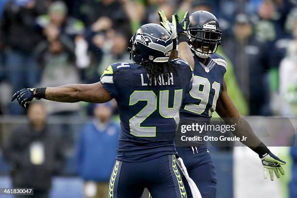 Defensive end Chris Clemons of the Seattle Seahawks celebrates with running back Marshawn Lynch after the Seahawks recover a fumble in the second...