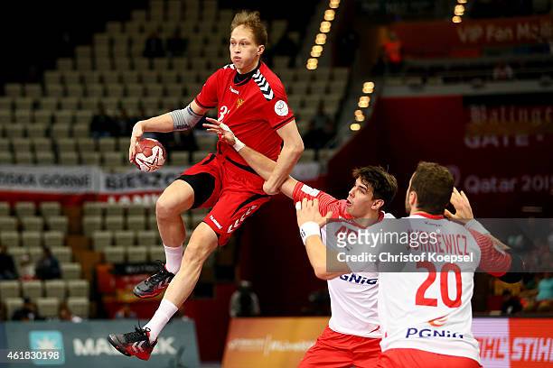 Piotr Chrapkowski and Mariusz Jurkiewicz of Poland defend against Alexander Dereven of Russia during the IHF Men's Handball World Championship group...