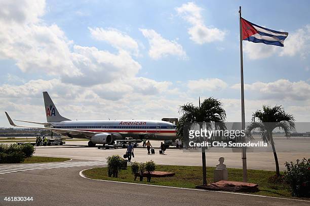 Passengers walk across the tarmac at Jose Marti International Airport after arriving on a charter plane operated by American Airlines January 19,...