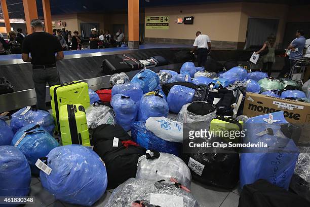 Garden of luggage and goods, wrapped in plastic to protect against tampering and theft, cover the baggae claim area at Jose Marti International...