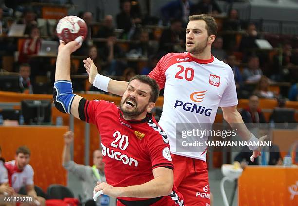 Russia's Mihail Chipurin attempts a shot on goal as Poland's Mariusz Jurkiewicz looks on during the 24th Men's Handball World Championships...