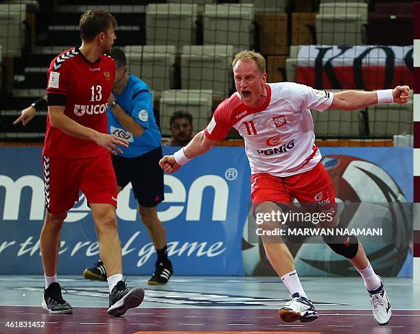 Poland's Adam Wisniewski celebrates his teams win as Russia's Sergey Sorbok looks on during the 24th Men's Handball World Championships preliminary...