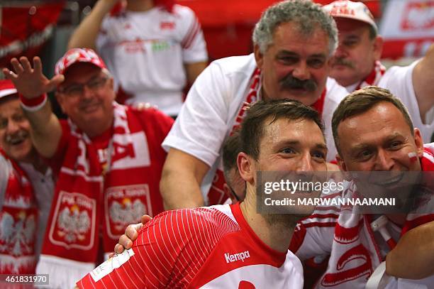 Poland's Andrzej Rojewski poses with fans after Poland won their match during the 24th Men's Handball World Championships preliminary round Group D...