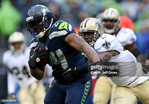 Running back Marshawn Lynch of the Seattle Seahawks runs the ball as he is grabbed by strong safety Roman Harper of the New Orleans Saints in the...