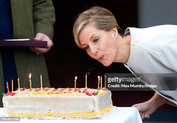 Sophie, Countess of Wessex blows out the candles on her birthday cake as she and Prince Edward, Earl of Wessex visit the Tomorrow's People Social...