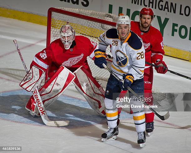 Tom McCollum of the Detroit Red Wings follows the playas teammate Niklas Kronwall defends against Zemgus Girgensons of the Buffalo Sabres during a...