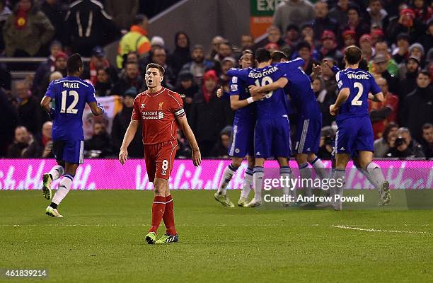 Steven Gerrard of Liverpool reacts as Eden Hazard of Chelsea celebrates with his team-mates after scoring the opening goal from the penalty spot...