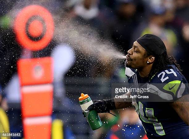 Running back Marshawn Lynch of the Seattle Seahawks spits out water in the fourth quarter while taking on the New Orleans Saints during the NFC...