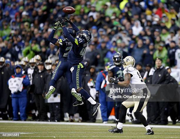Cornerback Byron Maxwell and free safety Earl Thomas of the Seattle Seahawks are unable to make an interception as the ball is caught by wide...