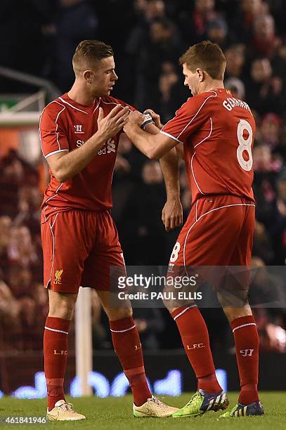 Liverpool's English midfielder Steven Gerrard gives the captain's armband to Liverpool's English midfielder Jordan Henderson as he is substituted...
