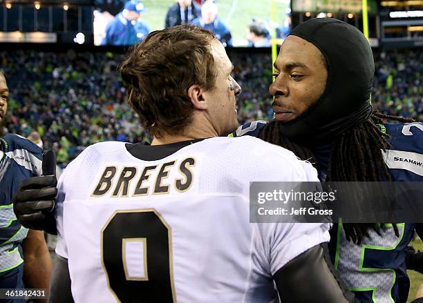 Cornerback Richard Sherman of the Seattle Seahawks hugs quarterback Drew Brees of the New Orleans Saints after the Seahawks 23-15 victory during the...