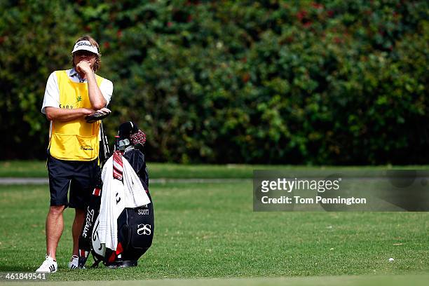 Big wave surfer Benji Weatherley caddies for Adam Scott of Australia during the third round of the Sony Open in Hawaii at Waialae Country Club on...