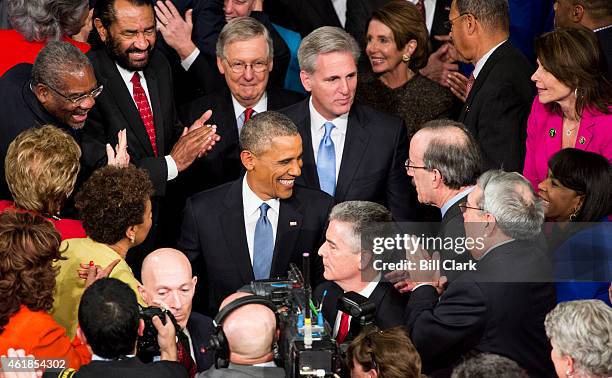 President Barack Obama greets members of Congress as he arrives in the House chamber in the U.S. Capitol to deliver his State of the Union address on...