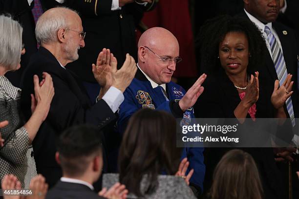 Astronaut Scott Kelly waves after being recognized by U.S. President Barack Obama during the State of the Union speech in the House chamber of the...