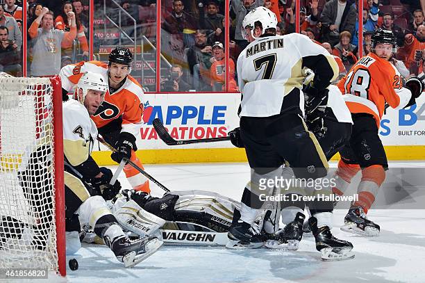 Brayden Schenn of the Philadelphia Flyers watches as the puck slips past Rob Scuderi and Thomas Greiss of the Pittsburgh Penguins for the game...