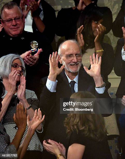 Aid worker Alan Gross, a former Cuban prisoner, center, is applauded as U.S. President Barack Obama, unseen, delivers the State of the Union address...