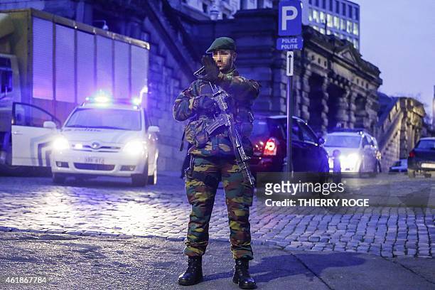 An armed soldier holds up his hand as heavy security measures were deployed all around the Palace of Justice in Brussels on January 21, 2015 for the...