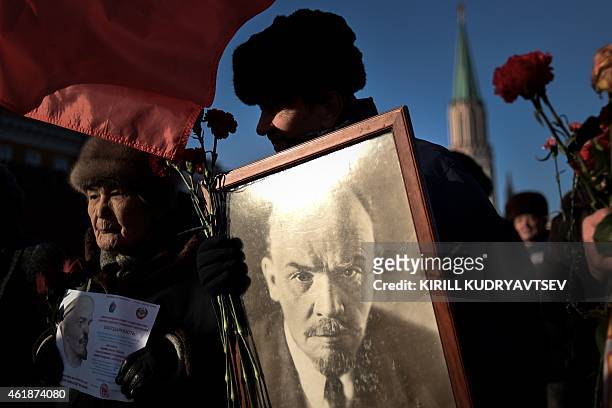Russian Communist Party supporters carry a portrait of late Soviet leader Vladimir Lenin as they take part in a memorial ceremony to mark the 91st...
