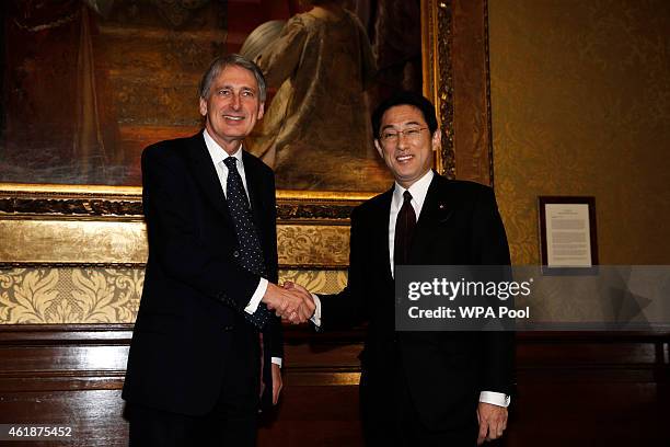 British Foreign Secretary Philip Hammond and Japanese Foreign Minister Fumio Kishida shake hands during a meeting at the Foreign and Commonwealth...