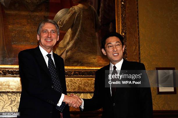 British Foreign Secretary Philip Hammond and Japanese Foreign Minister Fumio Kishida shake hands during a meeting at the Foreign and Commonwealth...