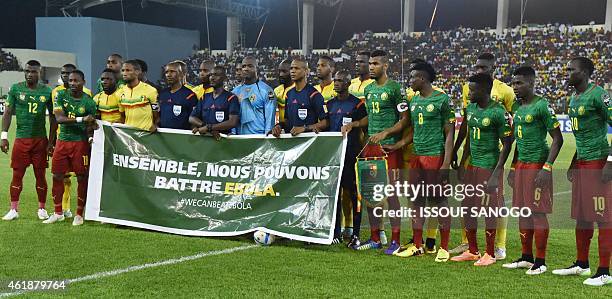 Cameroon's and Mali's players pose with a banner reading "Together we can beat Ebola" ahead of the 2015 African Cup of Nations group D football match...